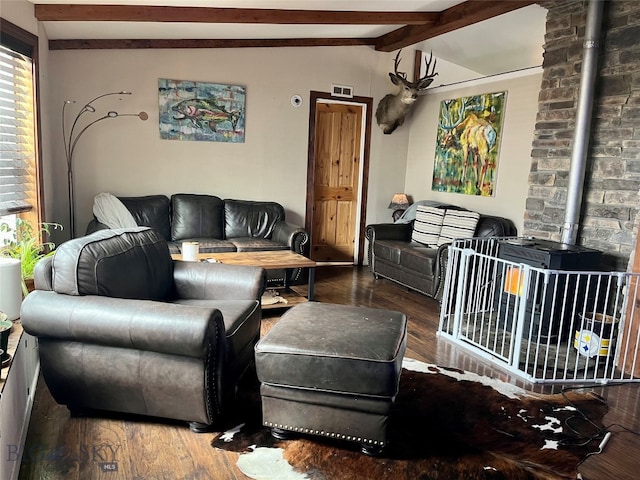 living room with wood-type flooring, vaulted ceiling with beams, and a wood stove