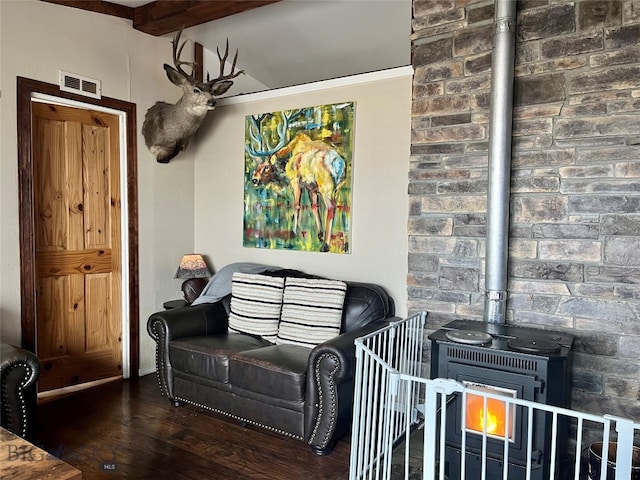 living room featuring a wood stove, dark wood-type flooring, and beam ceiling