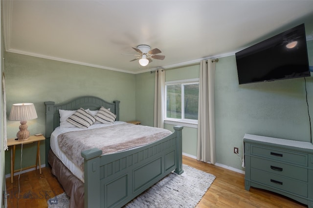 bedroom featuring light wood-type flooring, ceiling fan, and crown molding