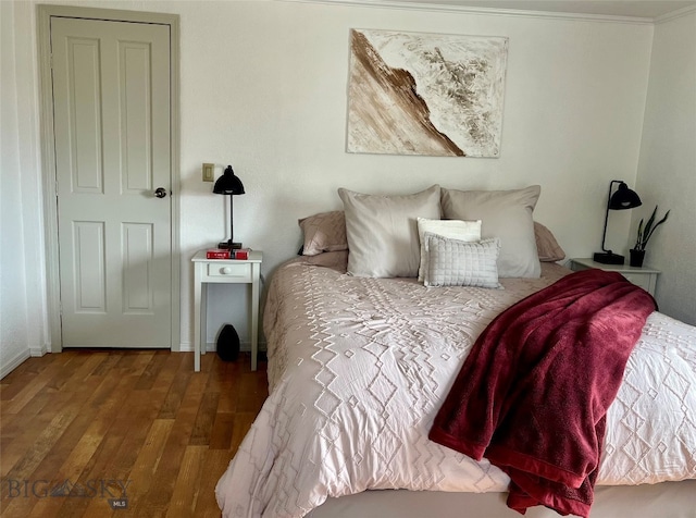 bedroom featuring hardwood / wood-style flooring and ornamental molding