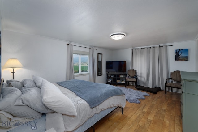 bedroom featuring hardwood / wood-style floors and crown molding