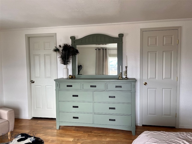 bedroom with hardwood / wood-style floors and crown molding