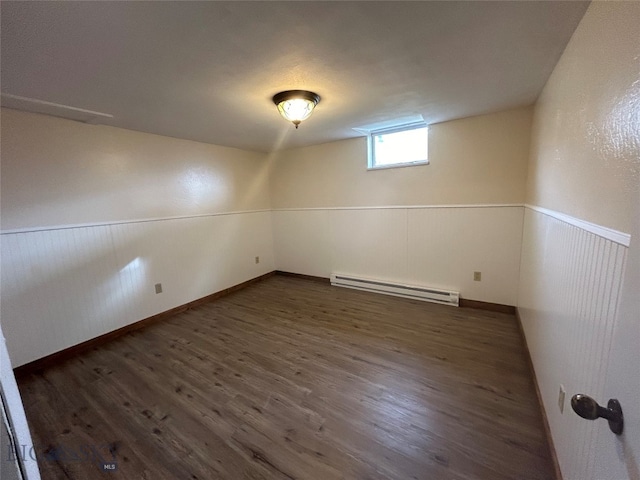 basement with dark wood-type flooring and baseboard heating