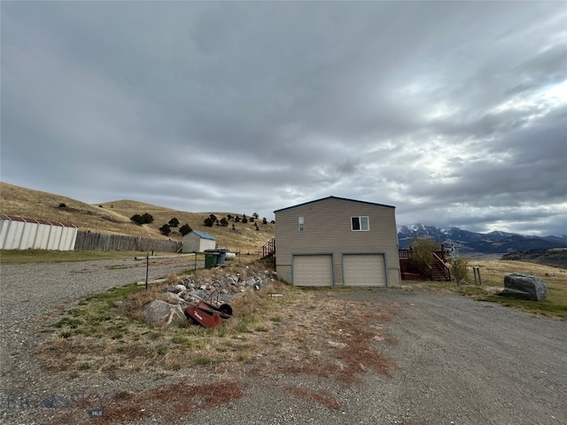 view of home's exterior with a mountain view and a garage