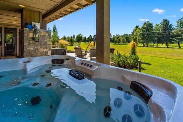 view of pool featuring a hot tub and a yard