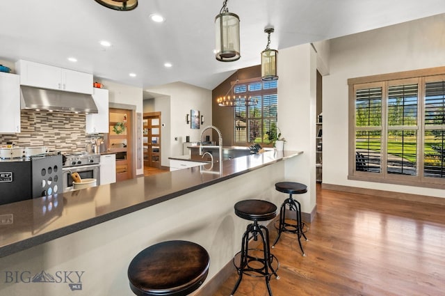 kitchen with pendant lighting, a wealth of natural light, white cabinetry, and exhaust hood