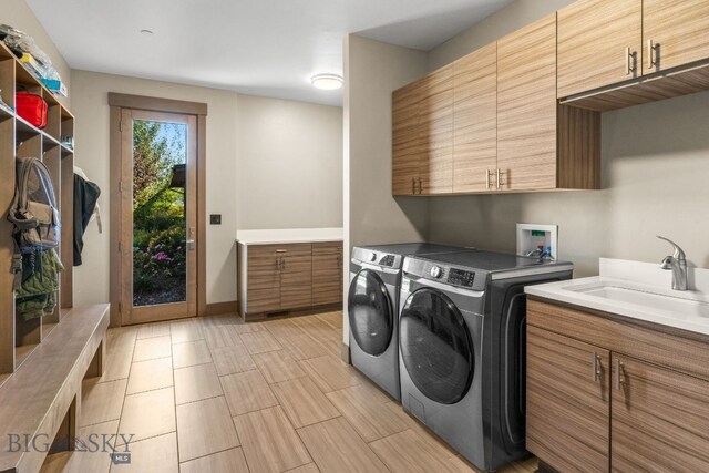 laundry area featuring cabinets, washer and dryer, and sink