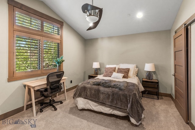 carpeted bedroom with vaulted ceiling, ceiling fan, and a barn door