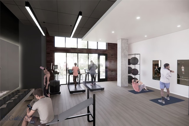 gym featuring hardwood / wood-style flooring and a towering ceiling