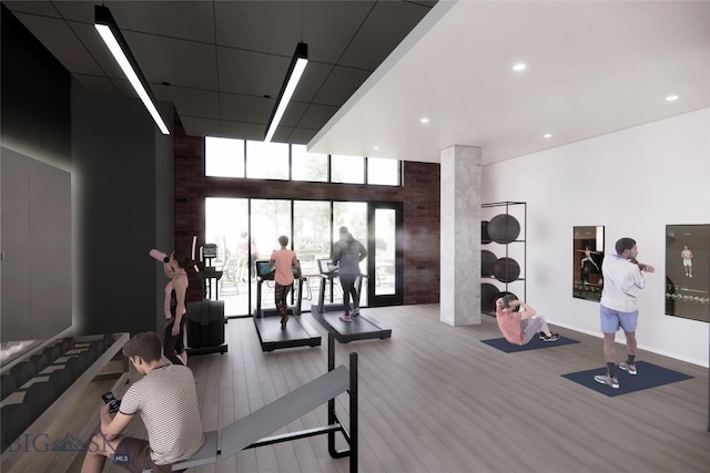 gym with baseboards, expansive windows, and wood finished floors