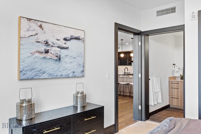 bedroom featuring hardwood / wood-style flooring and sink