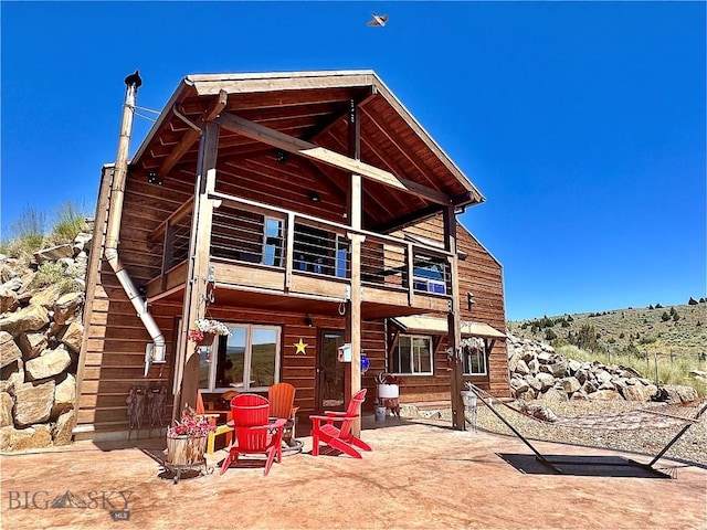 back of house featuring a balcony and a patio area