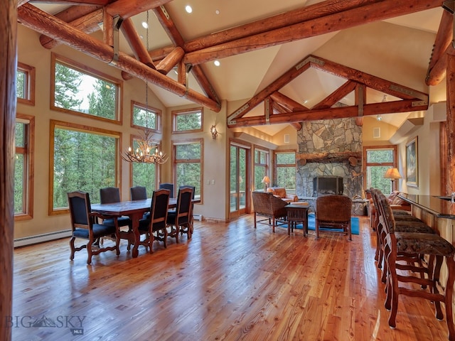 dining space with a baseboard heating unit, high vaulted ceiling, light wood-type flooring, beamed ceiling, and a fireplace