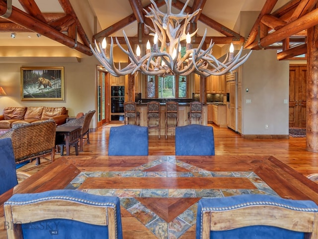 dining area featuring beamed ceiling, a chandelier, light hardwood / wood-style flooring, and high vaulted ceiling