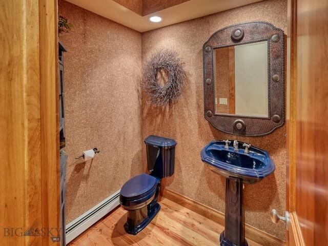 3686 Pinewood Dr, Big Sky, MT 59716 - half bath featuring a baseboard heating unit and wood finished floors