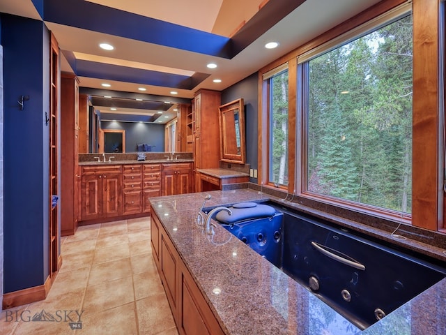 bathroom featuring vanity, tile patterned flooring, and a bath