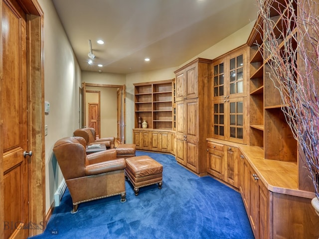 sitting room featuring dark carpet and ceiling fan