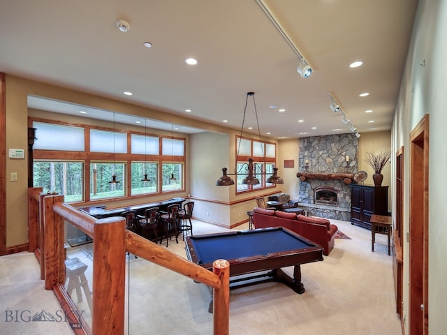 recreation room with light colored carpet, pool table, and a fireplace