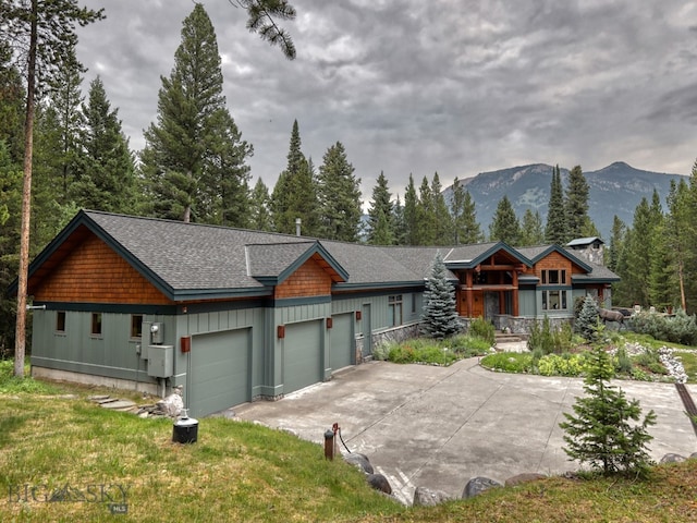 view of front of property with a mountain view, a front lawn, and a garage