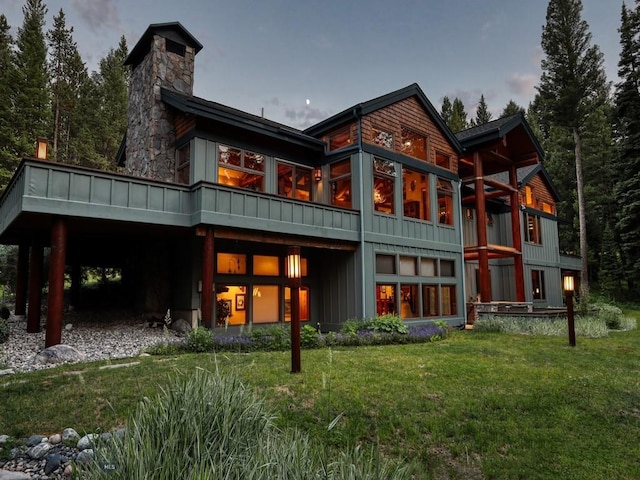 3686 Pinewood Dr, Big Sky, MT 59716 - back of property featuring a yard, board and batten siding, and a chimney