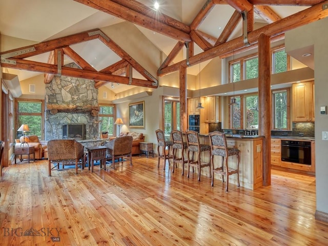 3686 Pinewood Dr, Big Sky, MT 59716 - kitchen featuring oven, high vaulted ceiling, dark countertops, light wood finished floors, and open floor plan