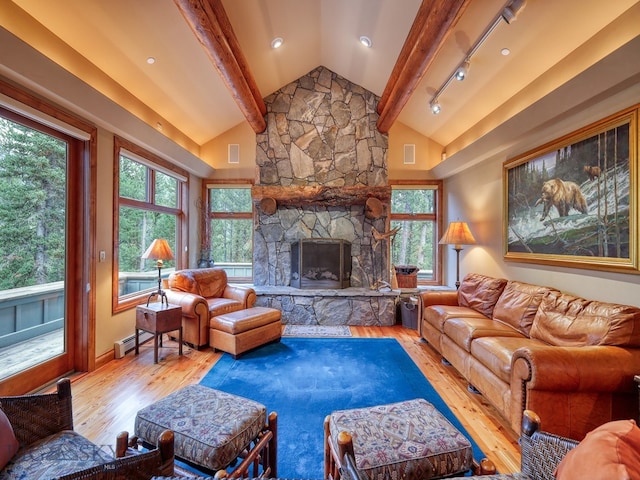 living room with light hardwood / wood-style flooring, a healthy amount of sunlight, lofted ceiling with beams, and a fireplace