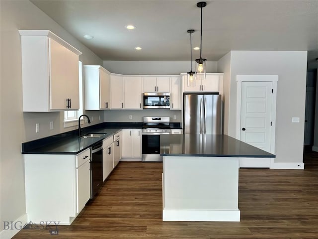 kitchen featuring white cabinets, decorative light fixtures, stainless steel appliances, and sink