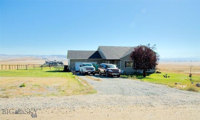 view of front facade with a mountain view, a garage, and a rural view