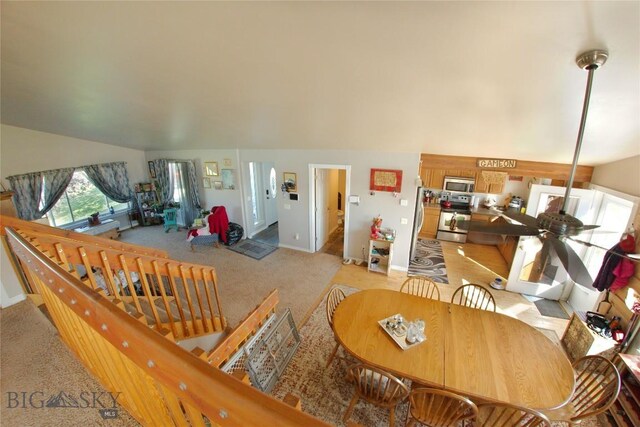 living room featuring vaulted ceiling, ceiling fan, and light colored carpet