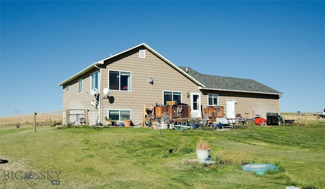 back of property featuring a lawn and a deck