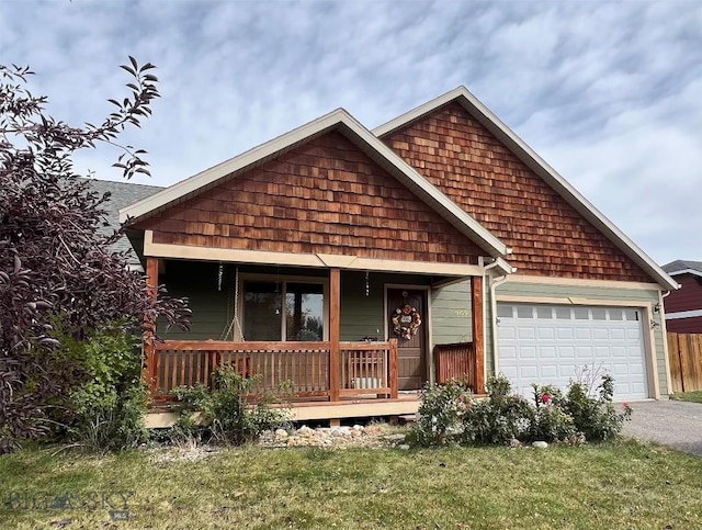 view of front of property with a garage, covered porch, and a front lawn