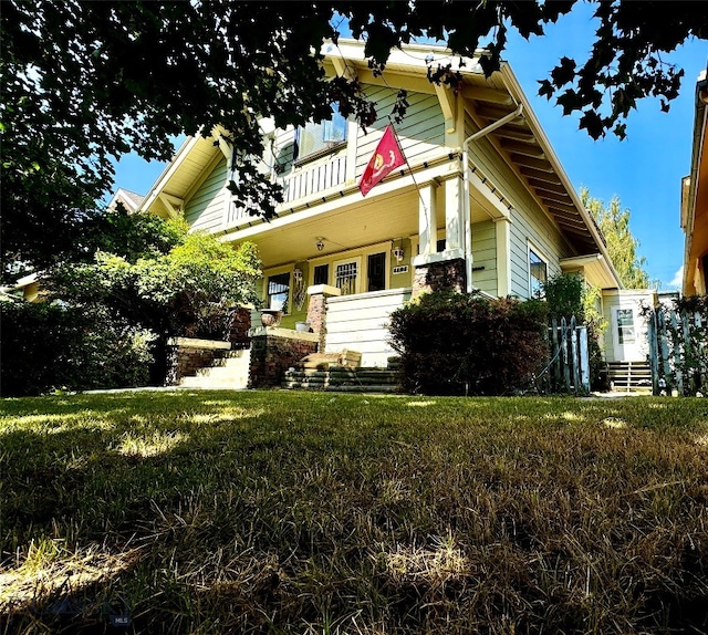 view of front of property featuring a balcony and a front lawn