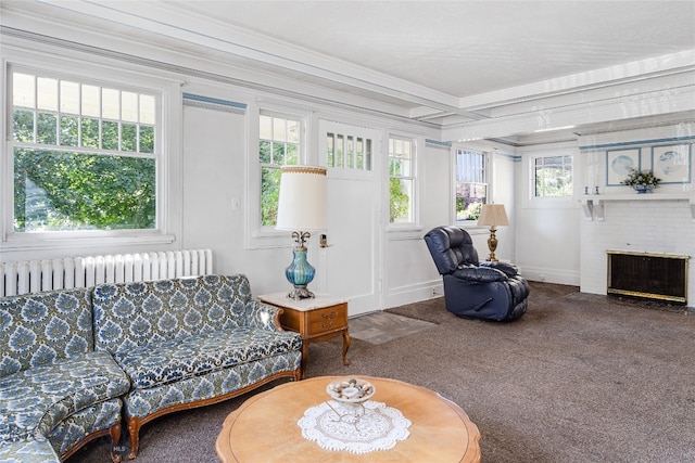 carpeted living room featuring a brick fireplace, crown molding, and radiator heating unit