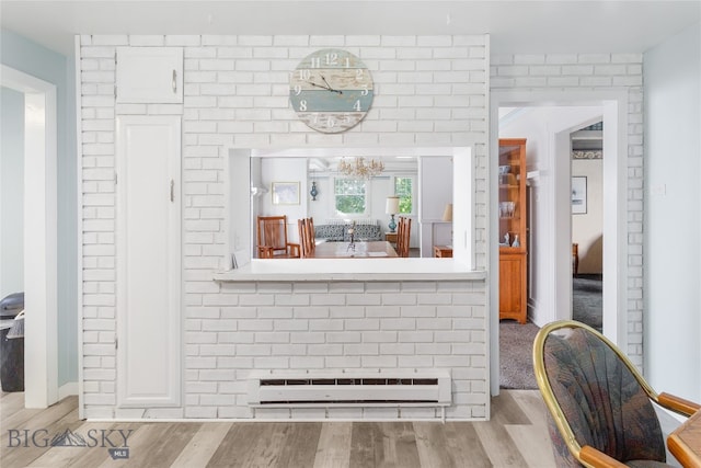 interior space featuring a baseboard radiator, a chandelier, and light hardwood / wood-style floors