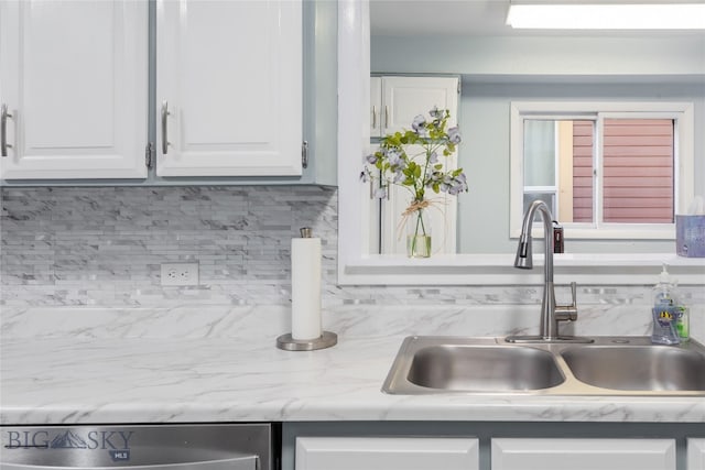 details featuring backsplash, sink, and white cabinets