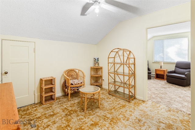 sitting room featuring carpet flooring, vaulted ceiling, a textured ceiling, and ceiling fan