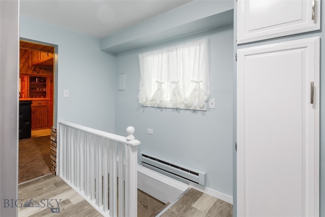 hallway with a baseboard radiator and light hardwood / wood-style flooring