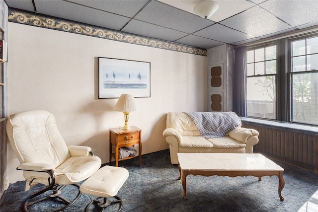 sitting room with carpet floors and a drop ceiling