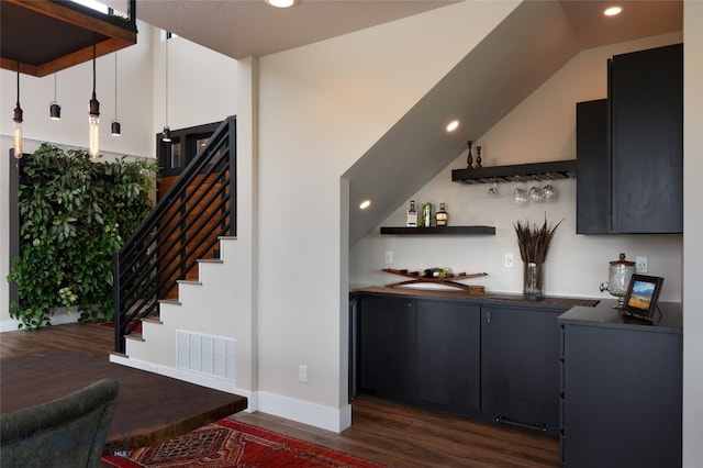 bar with vaulted ceiling and dark hardwood / wood-style flooring