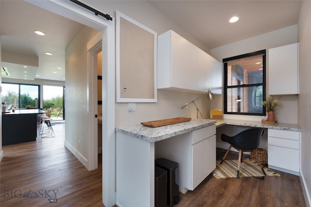 kitchen with white cabinets, built in desk, and dark hardwood / wood-style flooring