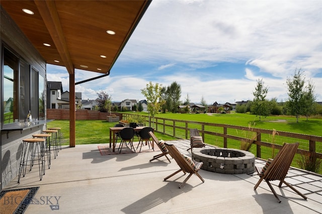 view of patio / terrace with a bar and an outdoor fire pit