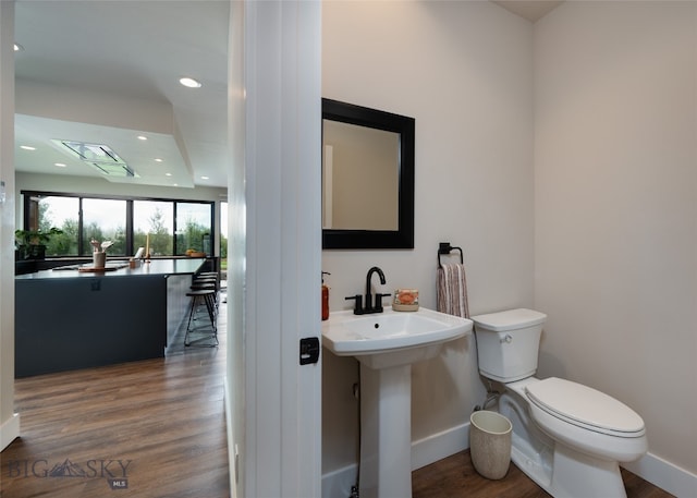 bathroom featuring toilet, sink, and hardwood / wood-style flooring