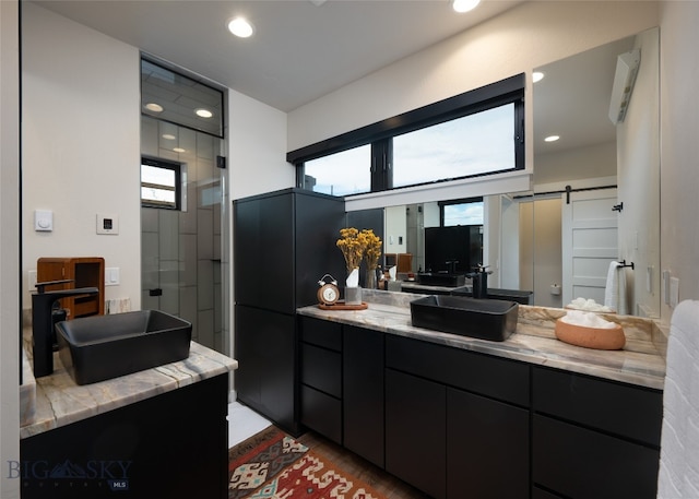 bathroom featuring a shower with door and vanity