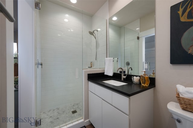 bathroom with vanity, toilet, and a shower with shower door