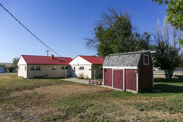 1112 Pritchard NW, Harlowton, MT 59036 - rear view of house with a lawn, an outdoor structure, a storage shed, a gambrel roof, and metal roof