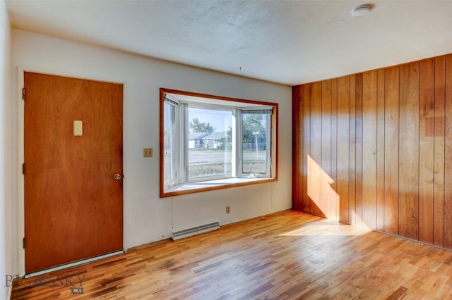 foyer with light wood-type flooring and wood walls