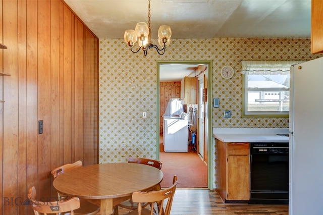 dining area featuring wood-type flooring, wooden walls, and a chandelier