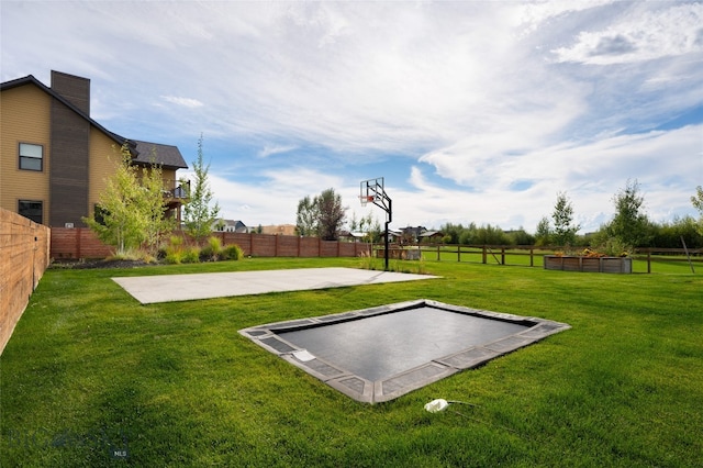 view of basketball court with a yard