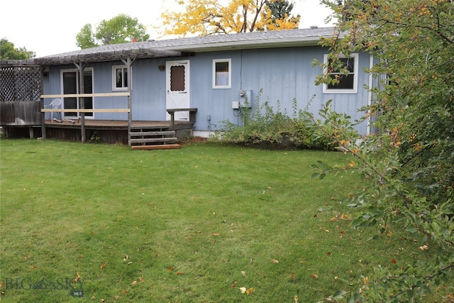 back of house featuring a wooden deck and a yard