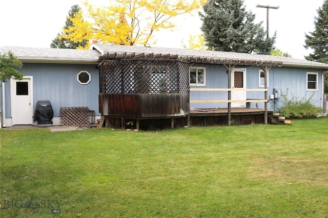 rear view of property featuring a lawn